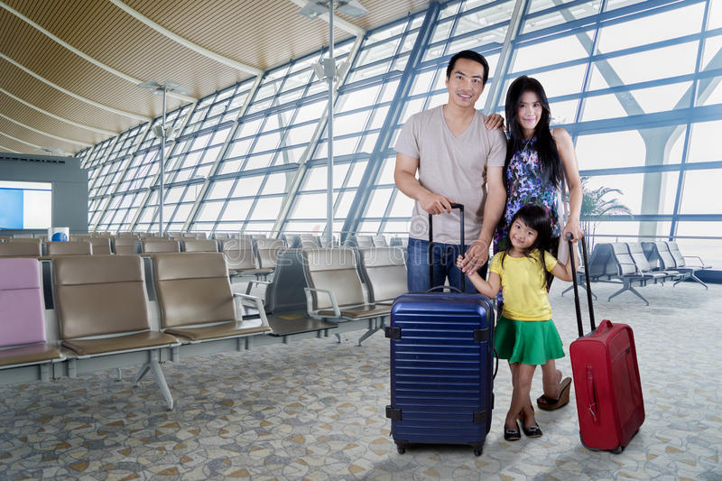 happy-family-smiling-airport-portrait-camera-standing-terminal-their-suitcase-87761414.jpg